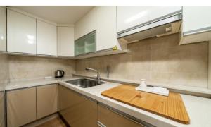 a kitchen with a sink and a wooden cutting board at Incheon Wolmido Stellamaris Hotel in Incheon