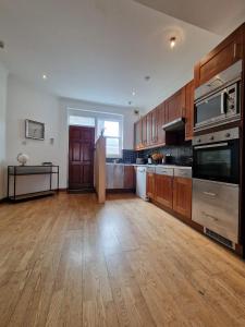 a large kitchen with wooden floors and stainless steel appliances at Farringdon in London