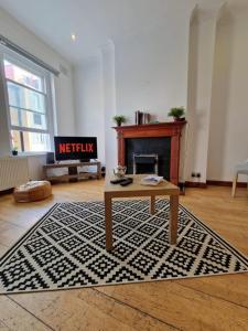 a living room with a table and a fireplace at Farringdon in London
