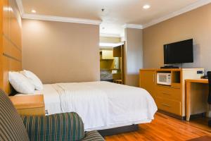 um quarto de hotel com uma cama e uma televisão de ecrã plano em Days Inn by Wyndham San Francisco S/Oyster Point Airport em South San Francisco