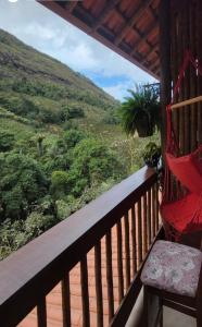 a porch with a hammock and a view of a mountain at Pousada Sítio das Pedras in Domingos Martins