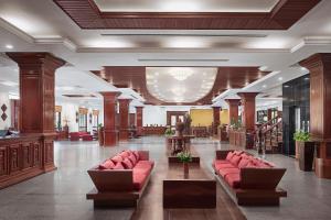 a lobby with red couches in a building at Angkor Paradise Hotel in Siem Reap