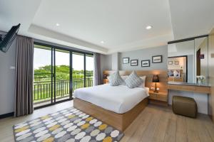 Raweewan Residence hotel في بانكوك: غرفة نوم بسرير كبير وبلكونة