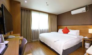 a hotel room with a large white bed with red pillows at Incheon Wolmido Stellamaris Hotel in Incheon