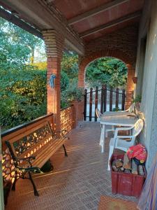 a porch with two benches and a table on it at La casa di Lili in Lugnano in Teverina