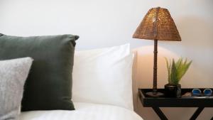 a lamp on a side table next to a bed at Bluebird Cottage in Bowral