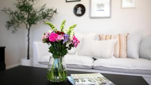 a vase of flowers on a table in a living room at Bluebird Cottage in Bowral +16 photos