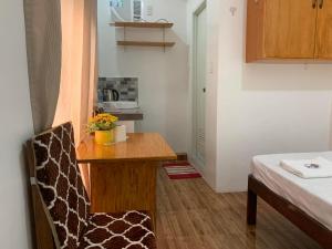スリガオにあるJCV Roomsの木製テーブルと椅子が備わる小さな客室です。