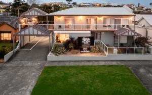 une grande maison avec une pelouse devant elle dans l'établissement City Heart Motel Warrnambool, à Warrnambool