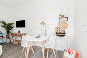 a white dining room with a white table and chairs at Vanderbilt Beach Studio in Naples