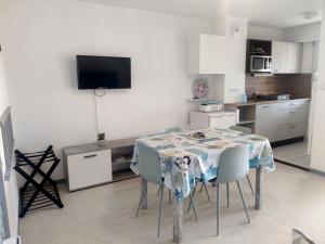 a kitchen with a table and chairs in a room at Charmant apt famille avec balcon au Port du Crouesty, parking inclus - FR-1-639-55 in Arzon