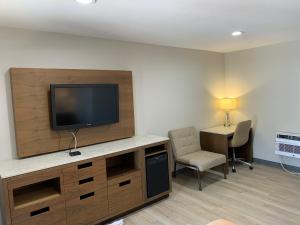 a room with a tv and a chair and a desk at Big 7 Motel in Chula Vista
