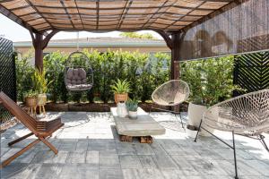 a patio with chairs and a wooden pergola at Vanderbilt Beach Studio in Naples