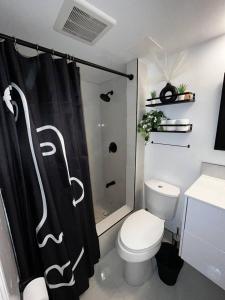 a bathroom with a toilet and a shower curtain at 1 bedroom with private entrance in Ajax