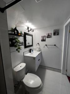 a white bathroom with a toilet and a sink at 1 bedroom with private entrance in Ajax