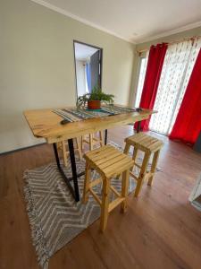 a wooden table and two stools in a room at Casa Montegrande in Monte Grande