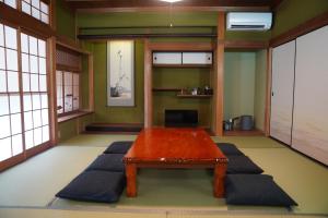 sala de estar con mesa de madera y bancos en LOOP-shiso en Shiso