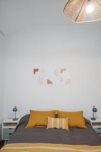 een slaapkamer met een bed en een witte muur bij Anden Aristides in Mendoza