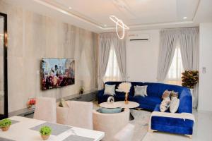 - un salon avec un canapé bleu et une table dans l'établissement Luxury 4bed Harris Drive Lekki, à Lagos