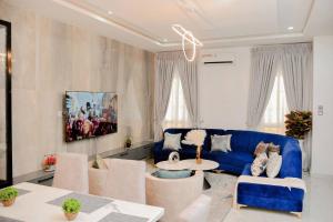 a living room with a blue couch and a table at Luxury 4bed Harris Drive Lekki in Lagos