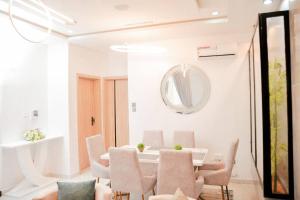 una sala da pranzo con tavolo, sedie e specchio di Luxury 4bed Harris Drive Lekki a Lagos