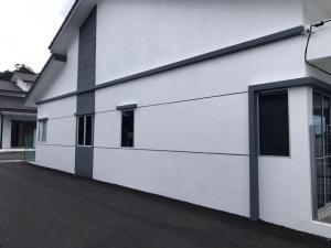 a white building with windows on the side of it at Al Ghazali Homestay in Seri Iskandar