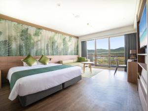 1 dormitorio con cama grande y ventana grande en Resort Hotel Kume Island, en Kumejima
