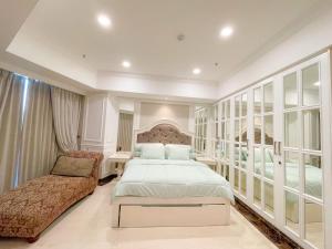 een slaapkamer met een groot bed en een stoel bij Elegance penthouse in Surabaya