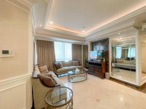 uma sala de estar com um sofá e uma televisão em Elegance penthouse em Surabaya