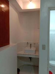 a bathroom with a sink and a toilet at JCV Rooms in Surigao