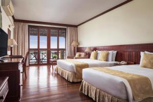 a hotel room with two beds and a balcony at Angkor Paradise Hotel in Siem Reap