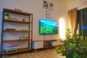 Monstera Meritus Homestay - Penang Butterworth Prai 1-8PAX في بيراي: غرفة معيشة مع تلفزيون بشاشة مسطحة على جدار