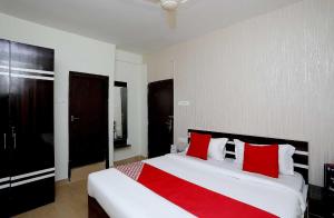 - une chambre avec un grand lit blanc et des oreillers rouges dans l'établissement OYO Flagship 16892 The Resting Place, à Pānchuria