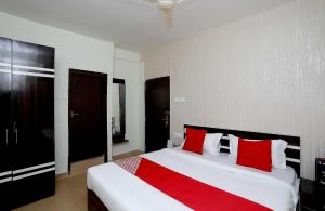 - une chambre avec un grand lit blanc et des oreillers rouges dans l'établissement OYO Flagship 16892 The Resting Place, à Pānchuria
