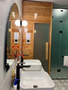 ein Badezimmer mit einem WC, einem Waschbecken und einem Spiegel in der Unterkunft AnAn Sweethome Penhouse Duplex near Bát Tràng in HÆ°ng YÃªn