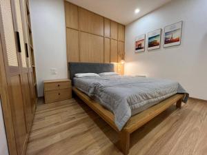 ein Schlafzimmer mit einem großen Bett und einer Holzwand in der Unterkunft AnAn Sweethome Penhouse Duplex near Bát Tràng in HÆ°ng YÃªn