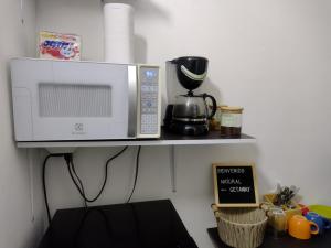 a microwave sitting on a shelf next to a table at Natural Getaway in Bogotá