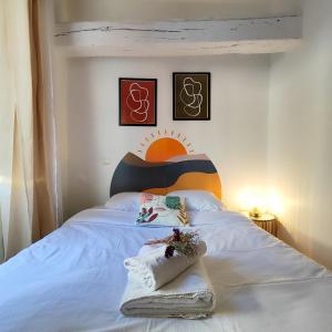 sypialnia z białym łóżkiem z kolorowym zagłówkiem w obiekcie Numéro 6 - Place Nationale - Wifi et Fibre w mieście Montauban