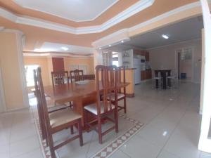 a dining room with a wooden table and chairs at Casa Veraneio pra família toda! in Xangri-lá