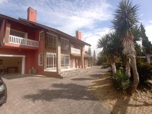 a red house with palm trees in front of it at Casa Veraneio pra família toda! in Xangri-lá