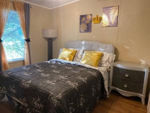 a bedroom with a bed and a lamp and a window at Kozy Kuntry Retreat in Bryan