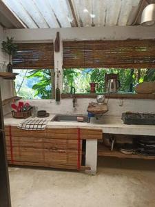 une cuisine avec un évier et une fenêtre dans l'établissement Refugio Natural Jacaranda CON PLAYA PRIVADA, à Cocorná