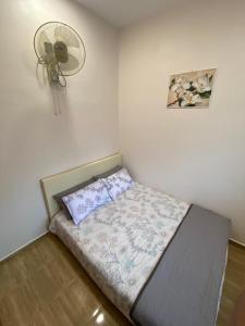 a small bedroom with a bed with a fan at Palas Tiny Homestay in Changlun