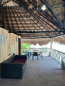 eine überdachte Terrasse mit einem Tisch und einem Tisch in der Unterkunft EcoHostal +EcoFit Natura in Playa Punta Arena