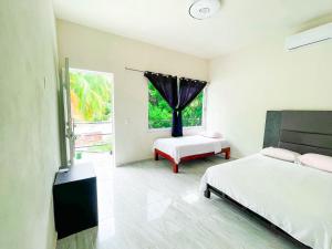 sypialnia z 2 łóżkami i oknem w obiekcie Hotel Vias Maya Bacalar w mieście Bacalar