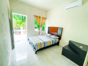 a small bedroom with a bed and a window at Hotel Vias Maya Bacalar in Bacalar