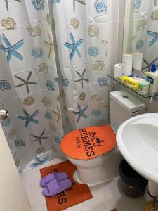 a bathroom with an orange toilet and a sink at Sirena Beach Chic Staycation at Azure Paris Beach Club in Manila