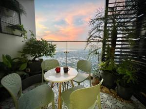 uma mesa e cadeiras numa varanda com vista em AnAn Sweethome Penhouse Duplex near Bát Tràng em HÆ°ng YÃªn