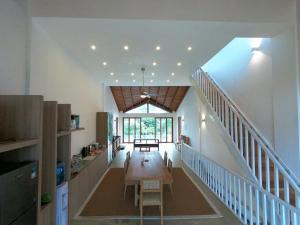 a living room with a table and a staircase at Vandalous Bay in Pasikuda