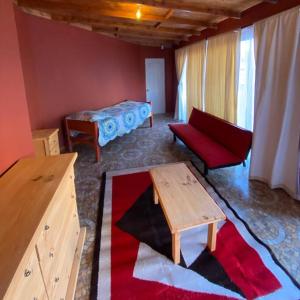 a living room with a red couch and a table at Cabaña Altos de Chanchoqui in Paihuano